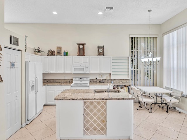 kitchen featuring white cabinetry, white appliances, pendant lighting, an inviting chandelier, and a kitchen island with sink