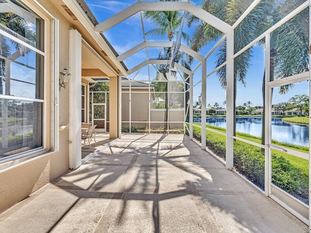 sunroom featuring a water view, vaulted ceiling, and a wealth of natural light