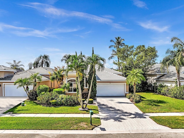 view of front of home with a garage and a front lawn