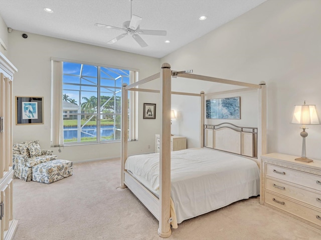 bedroom with light carpet, ceiling fan, and a textured ceiling