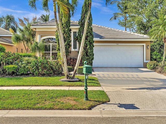 view of front of house featuring a garage and a front lawn