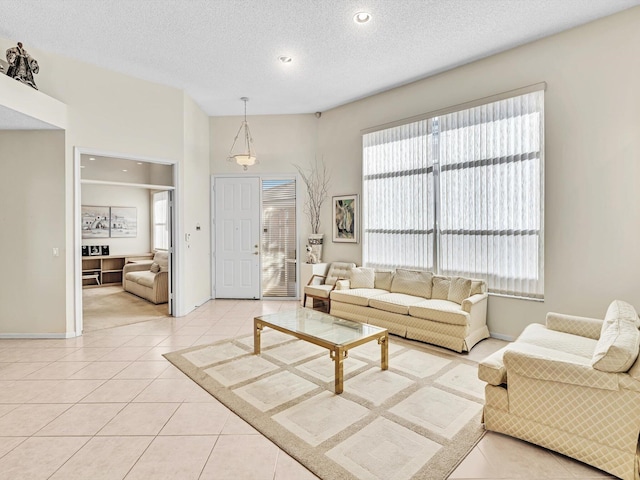 living room with a textured ceiling and light tile patterned flooring