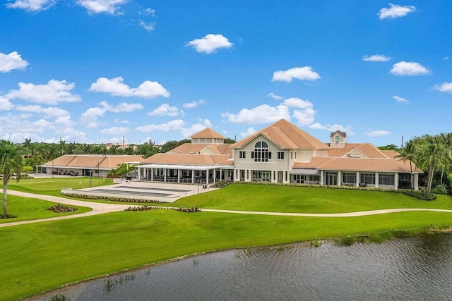 back of house featuring a lawn and a water view