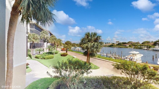 view of property's community featuring a yard, a dock, and a water view