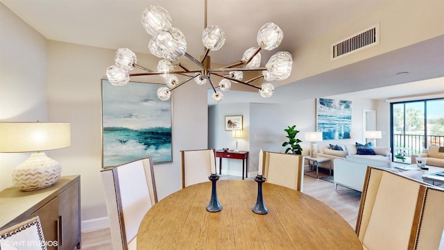 dining room with light hardwood / wood-style flooring and a notable chandelier