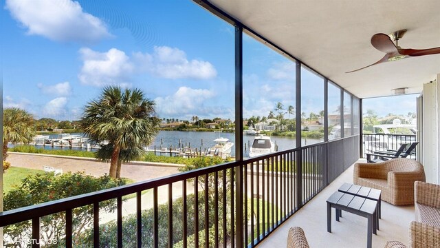 sunroom with a water view and ceiling fan