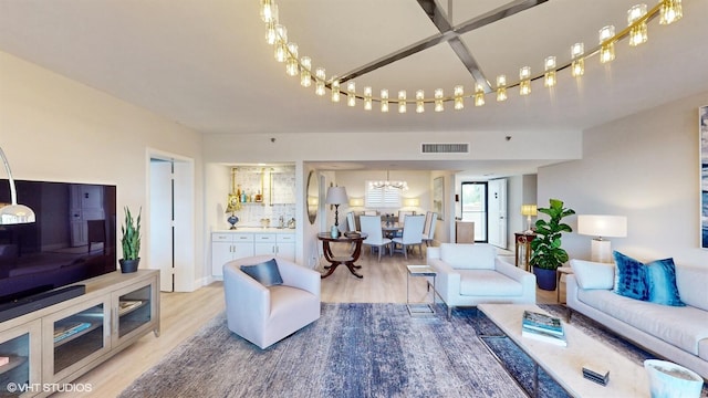 living room featuring a chandelier and light hardwood / wood-style floors