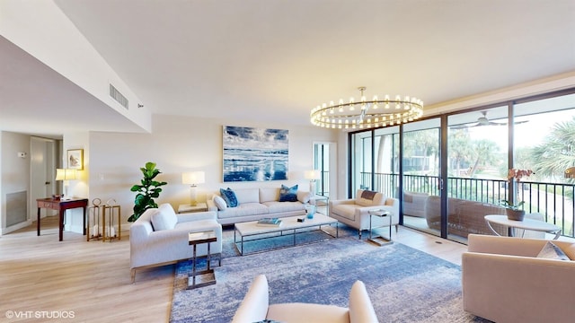 living room with an inviting chandelier and light hardwood / wood-style floors