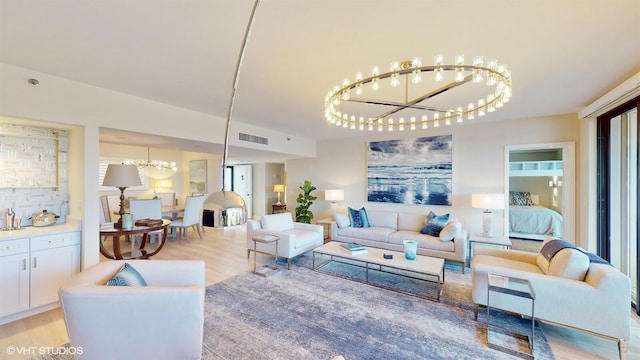 living room with light hardwood / wood-style floors and a chandelier