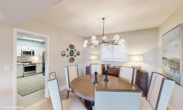 dining room with a notable chandelier and light wood-type flooring