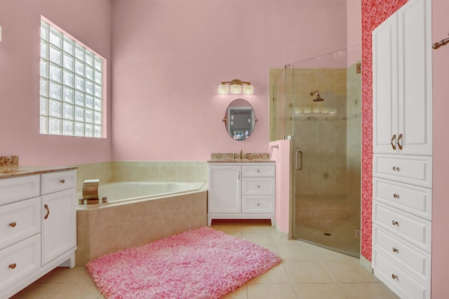 bathroom featuring tile patterned flooring, vanity, and shower with separate bathtub