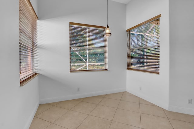 tiled spare room featuring a healthy amount of sunlight