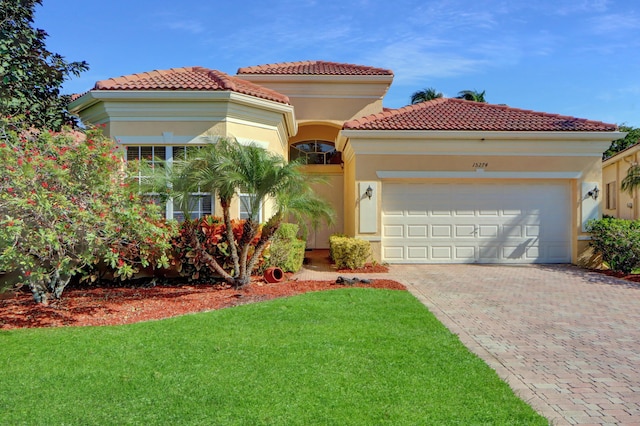 mediterranean / spanish-style house with a garage and a front lawn