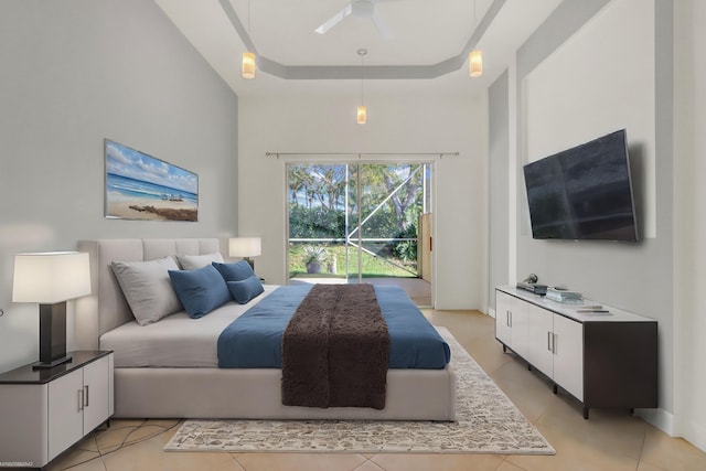 tiled bedroom featuring a raised ceiling and ceiling fan