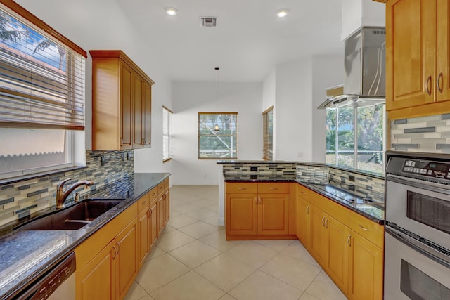 kitchen featuring decorative backsplash, dark stone counters, stainless steel appliances, extractor fan, and decorative light fixtures