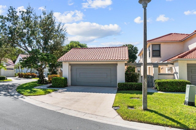 mediterranean / spanish-style house featuring a front yard and a garage