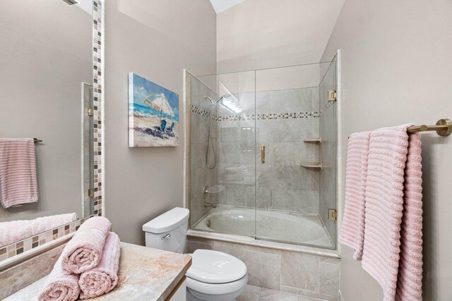 bathroom featuring tile patterned flooring, an enclosed shower, vanity, and toilet