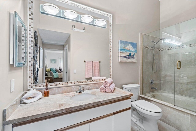 full bathroom featuring vanity, toilet, and combined bath / shower with glass door