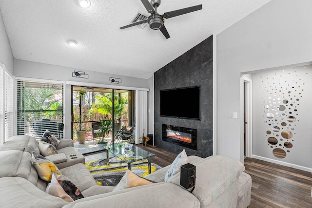 living room with ceiling fan, lofted ceiling, a high end fireplace, a textured ceiling, and dark hardwood / wood-style floors