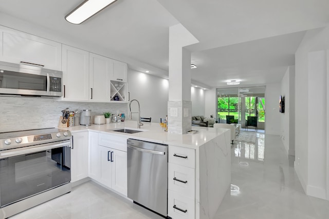 kitchen featuring white cabinets, sink, stainless steel appliances, and kitchen peninsula