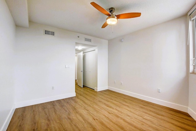 unfurnished room featuring ceiling fan, a textured ceiling, and light wood-type flooring