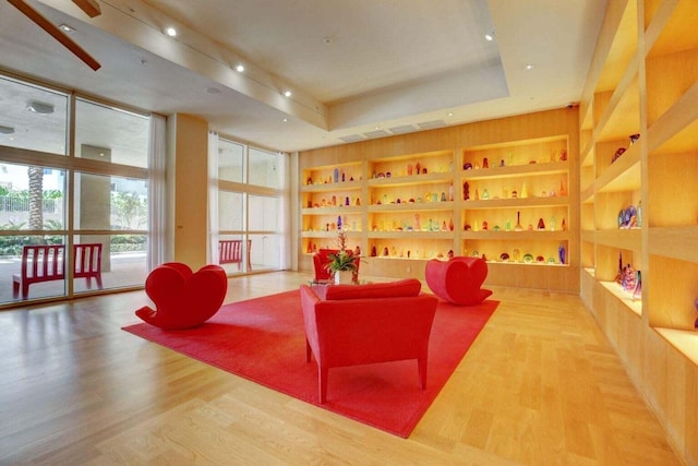 sitting room with expansive windows, bar area, hardwood / wood-style flooring, and built in features