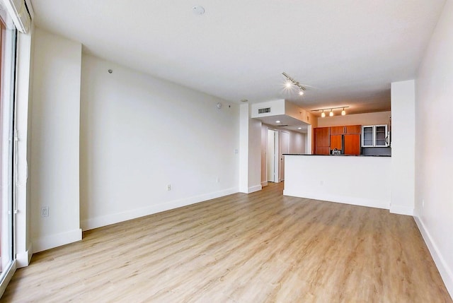 unfurnished living room featuring light hardwood / wood-style floors and rail lighting