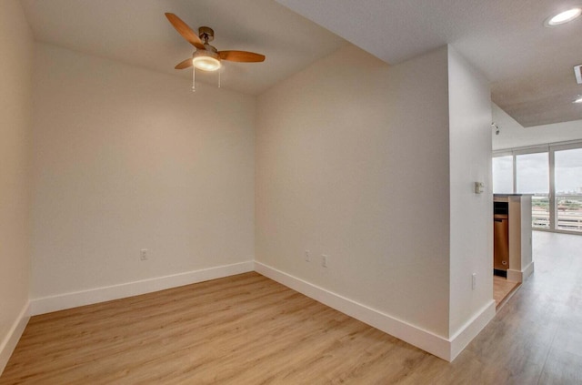 empty room with light hardwood / wood-style floors and ceiling fan