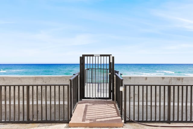 view of property's community featuring a water view and a beach view