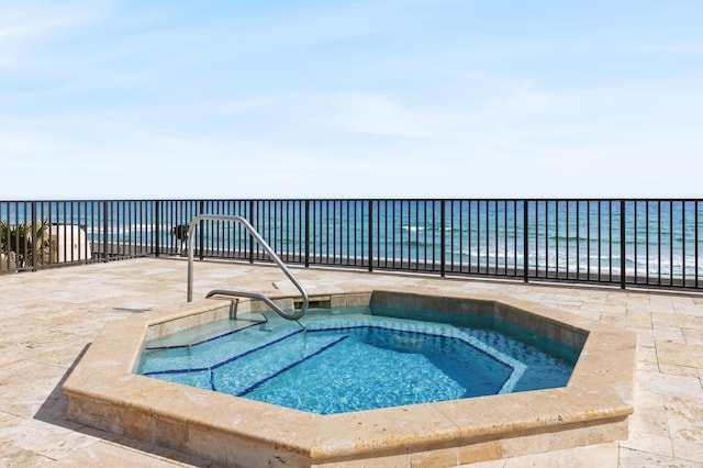 view of swimming pool featuring an in ground hot tub and a water view