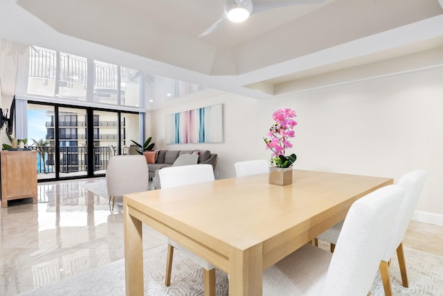 dining room featuring ceiling fan and expansive windows