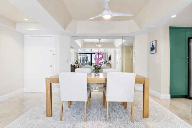 dining area featuring ceiling fan and a tray ceiling