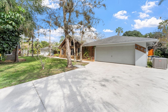 view of front of property with a garage, a front lawn, and central AC