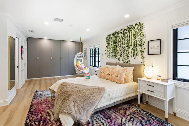 bedroom featuring light hardwood / wood-style flooring and crown molding