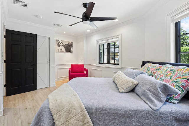 bedroom with light hardwood / wood-style flooring, ceiling fan, and ornamental molding