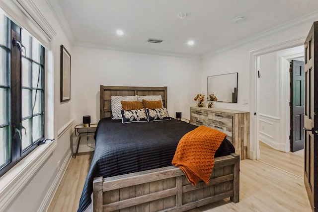 bedroom with light hardwood / wood-style floors and ornamental molding