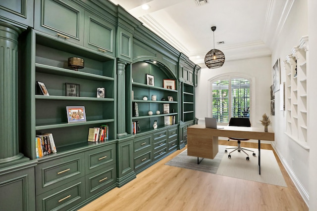 office space with built in shelves, crown molding, and hardwood / wood-style flooring