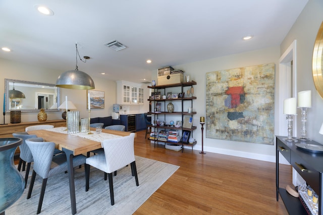 dining room with hardwood / wood-style floors and beverage cooler