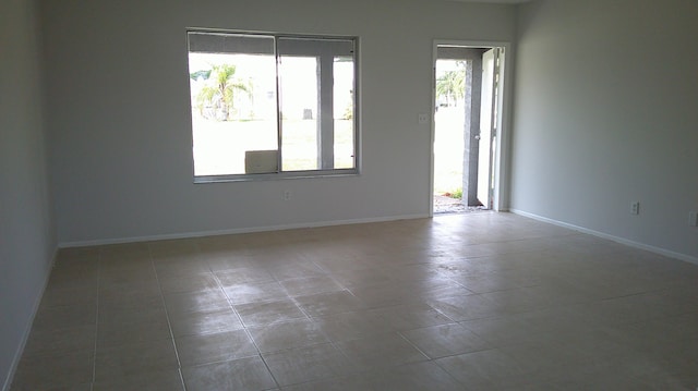 spare room featuring plenty of natural light and tile patterned flooring