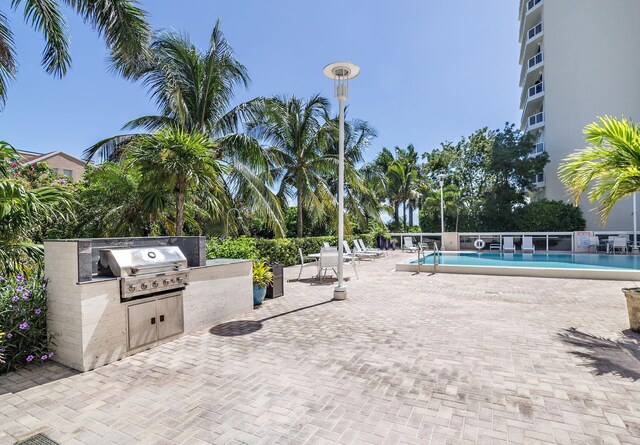 exterior space featuring a community pool, area for grilling, and an outdoor kitchen