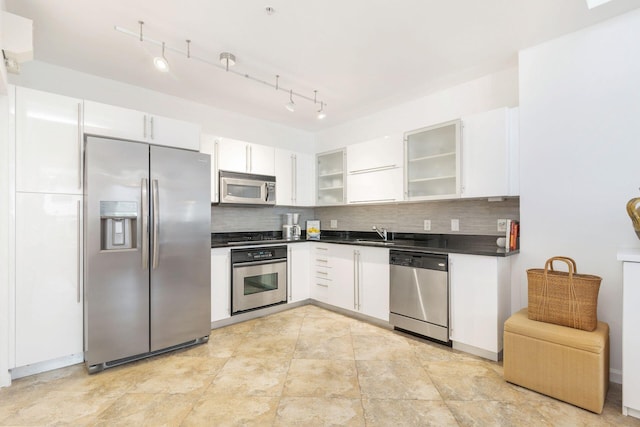 kitchen with appliances with stainless steel finishes, white cabinets, sink, and tasteful backsplash