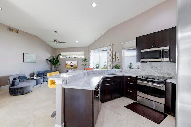 kitchen featuring appliances with stainless steel finishes, vaulted ceiling, light tile patterned floors, ceiling fan, and sink