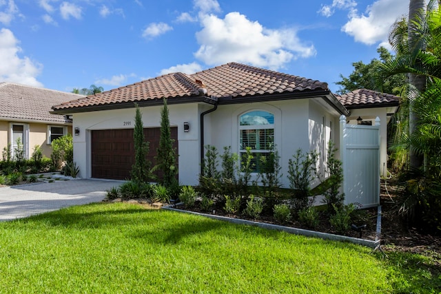 mediterranean / spanish-style house with a front yard and a garage