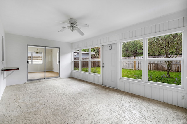 unfurnished sunroom featuring ceiling fan and plenty of natural light