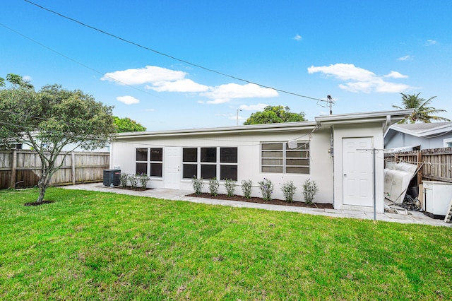 back of property with a yard and central air condition unit