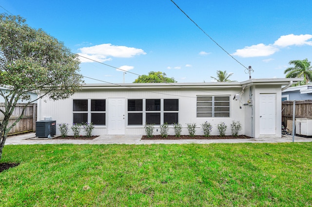 back of property featuring a yard and central AC