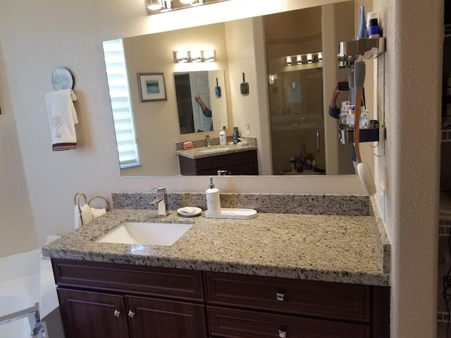 bathroom with walk in shower and vanity