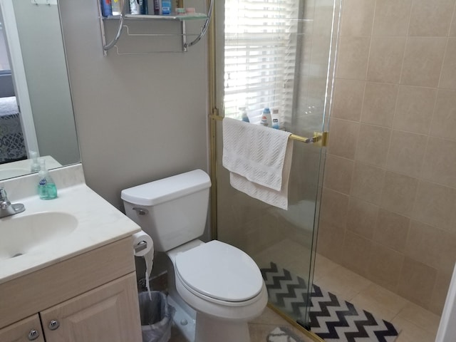 bathroom featuring vanity, toilet, a shower with door, and tile patterned floors