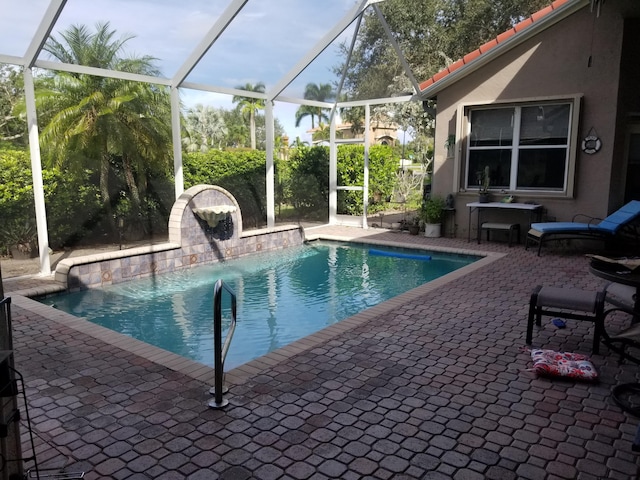 view of pool featuring glass enclosure, a patio area, and pool water feature