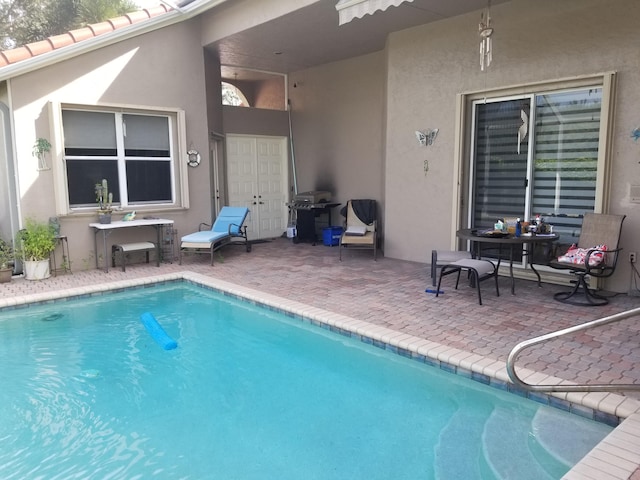 view of swimming pool with area for grilling and a patio